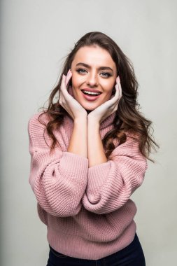 Genç kadın sürpriz yanakları el ile tutar. Şu beyaz arka plan üzerinde izole aramak için işaret eden güzel bir kız. Etkileyici yüz ifadeleri