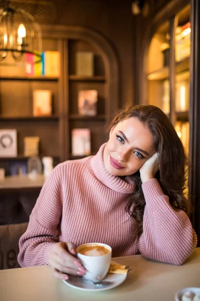 Young beautiful woman drinking coffee at cafe