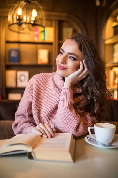 Giovane bella donna che legge libro interessante in caffè — Foto Stock