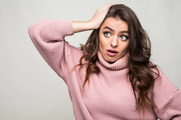 Scowling jeune femme grattant sa tête isolé sur blanc — Photo