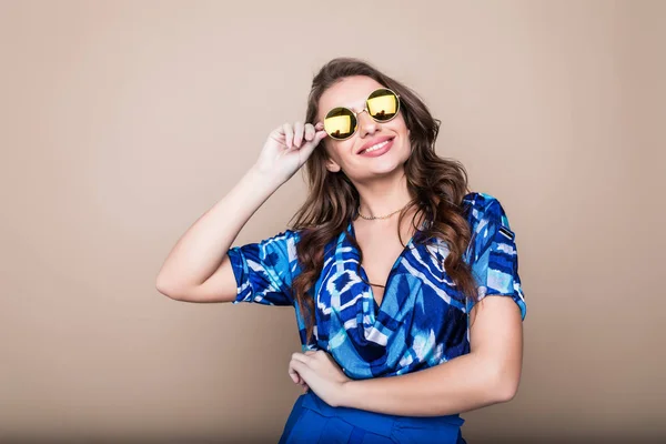 Belle joyeuse jeune femme d'été en lunettes de soleil debout sur un fond de couleur — Photo