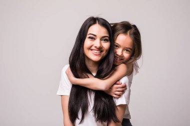 Küçük kızı annesi sırtıma beyaz arka plan üzerinde izole sarılmak
