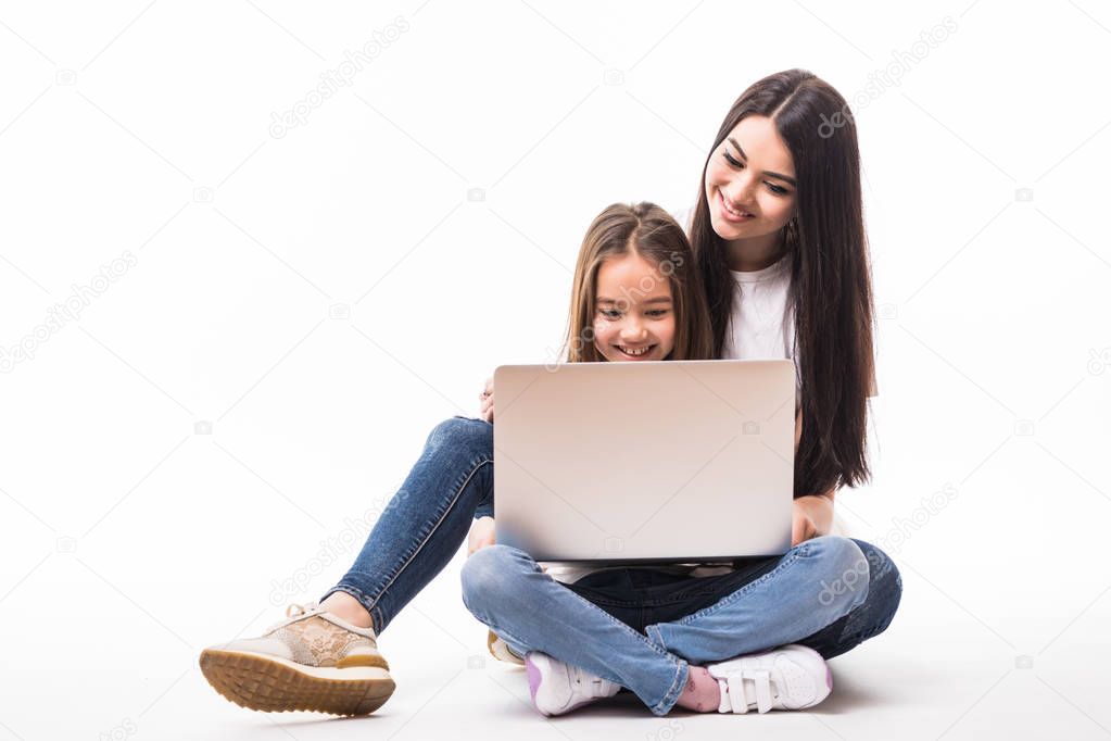 mother and daughter with laptop play games lying on the floor, isolated on white background