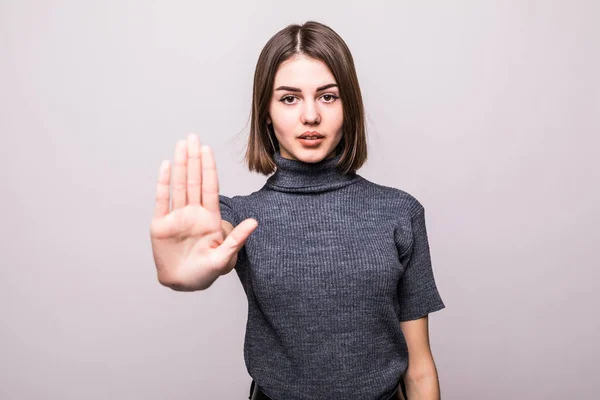Portréja egy komoly fiatal nő állt a kinyújtott kéz a mutatja a stop gesztus mint fehér háttér — Stock Fotó