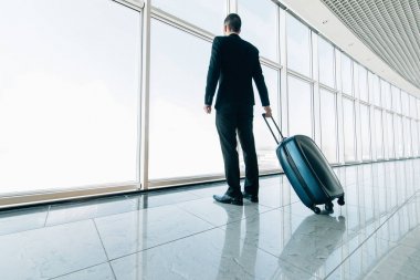 Uluslararası havaalanında uçak seyahat etmek için terminal kapısına hareketli iş adamı. Mobilite kavramı ve Havacılık ve uzay sanayi uçuş bağlantıları.