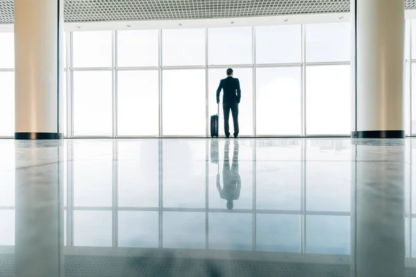 Homme d'affaires à l'aéroport avec valise en attente de vol retardé près de la porte d'embarquement. Voyages d'affaires — Photo