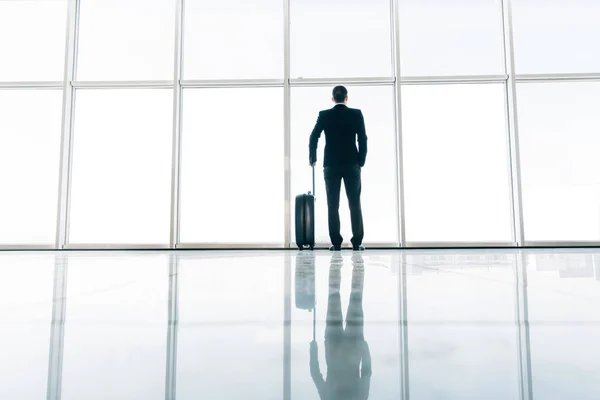 Arrière de l'homme d'affaires et valise à l'aéroport en attente du vol. Concept de voyage, concept de vacances d'été, valises de voyageur dans le terminal de l'aéroport . — Photo