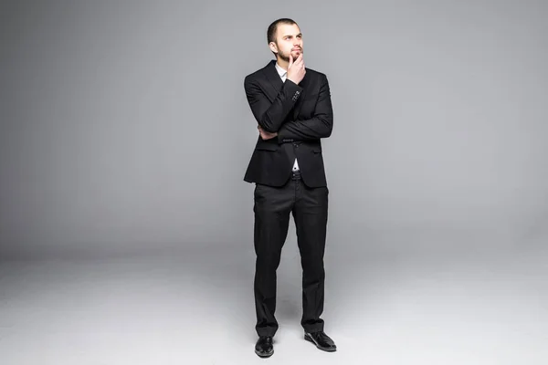 Gondolkodó fiatal üzletember keresi a elszigetelt fehér háttér — Stock Fotó