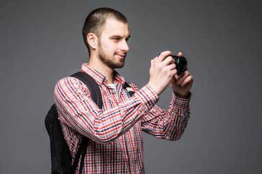 Sırt çantası, eski fotoğraf makinesi ile smartphone selfie Stick gri arka plan üzerinde neşeli genç turizm