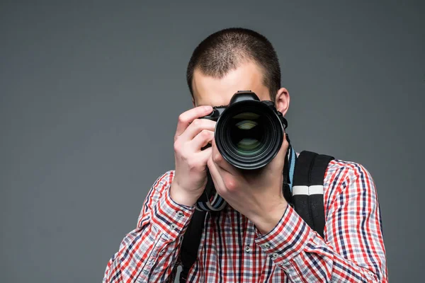 Porträtt av fotografen som tar bilder med digitalkamera isolerade på grå bakgrund — Stockfoto