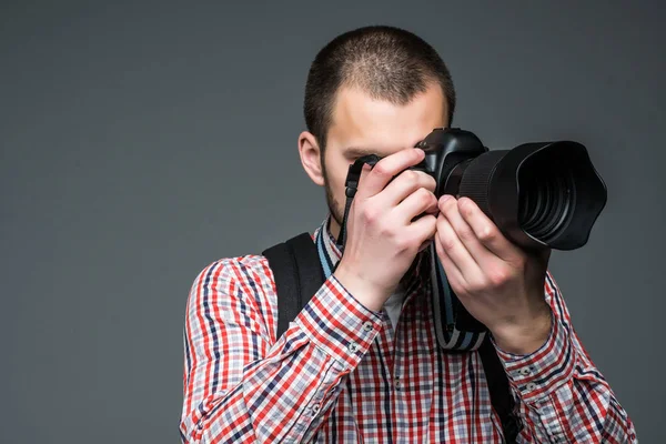 Manliga yrkesfotograf med digitalkamera isolerad på grå — Stockfoto