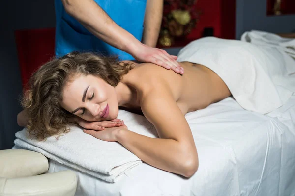 Masajista haciendo masaje en el cuerpo de la mujer en el salón de spa. Concepto de tratamiento de belleza. Asistencia sanitaria — Foto de Stock