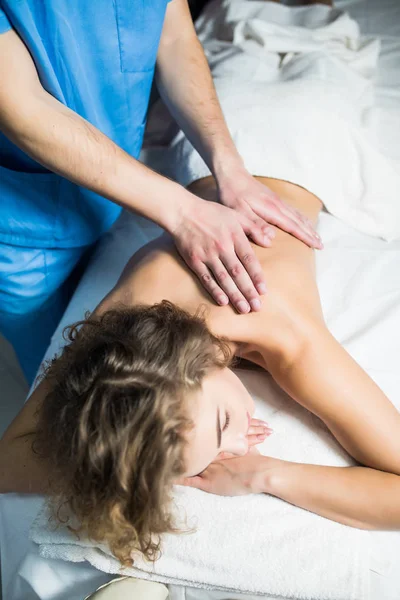 Vista superior de la mujer que recibe masaje de espalda en el spa. Mujer teniendo masaje relajante en su espalda en el spa . — Foto de Stock