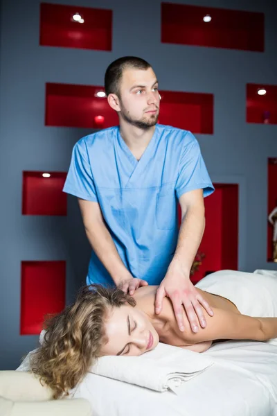 Man massagetherapeut masseren achterkant mooie vrouw — Stockfoto