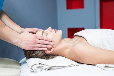 spa salonda genç kadın yüzünü bir masaj