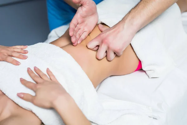 Masajista realiza masaje anti-celulitis del abdomen de la mujer — Foto de Stock
