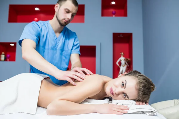 Zdraví, krása, resort a relaxační koncept - krásná žena se zavřenýma očima v lázeňském salonu při masáži — Stock fotografie