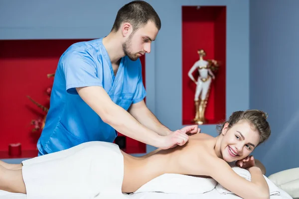 Masér dělá masáž na těle ženy v lázeňském salonu. Zdravotnické koncepce. — Stock fotografie