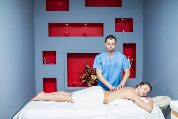 Masseur macht Massage auf Frauenkörper im Wellness-Salon. — Stockfoto