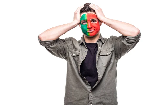 Hombre guapo partidario fan de Portugal equipo nacional pintado bandera cara infeliz triste frustrado emociones en una cámara. Aficionados emociones . — Foto de Stock