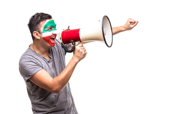Handsome man supporter loyal fan of Iran national team painted flag face get happy victory screaming into megaphone with pointed hand. Fans emotions. — Stock Photo, Image