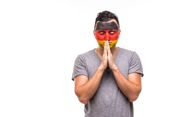 Hombre guapo partidario leal fan de la selección nacional de Alemania con la cara pintada bandera rezar en blanco. Aficionados emociones . — Foto de Stock