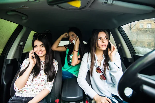 Three young best friends in the car and use smart phone while drive car