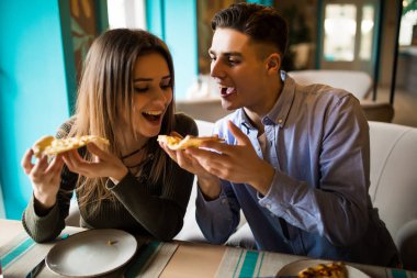 Pizza paylaşımı ve birlikte mutlu bir şekilde yemek kafede bir çift. Pizza zamanı.