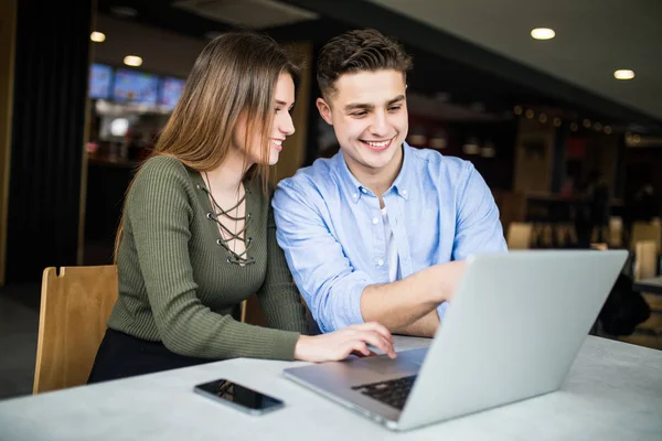 Et ungt par jobber på en laptop. – stockfoto