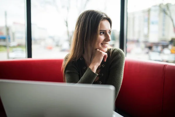 Hermosa mujer joven usando el ordenador portátil en la cafetería — Foto de Stock