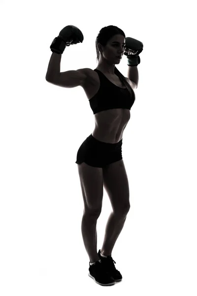Silhouette sporty woman doing boxing exercises, making direct hit with dumbbells. Photo of muscular female wearing sportswear on white background. Strength and motivation — Stock Photo, Image