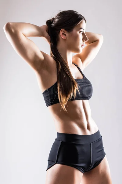 Sport. Frau Sport Körper stark und schön mit sprong Presse isoliert auf grauem Hintergrund — Stockfoto