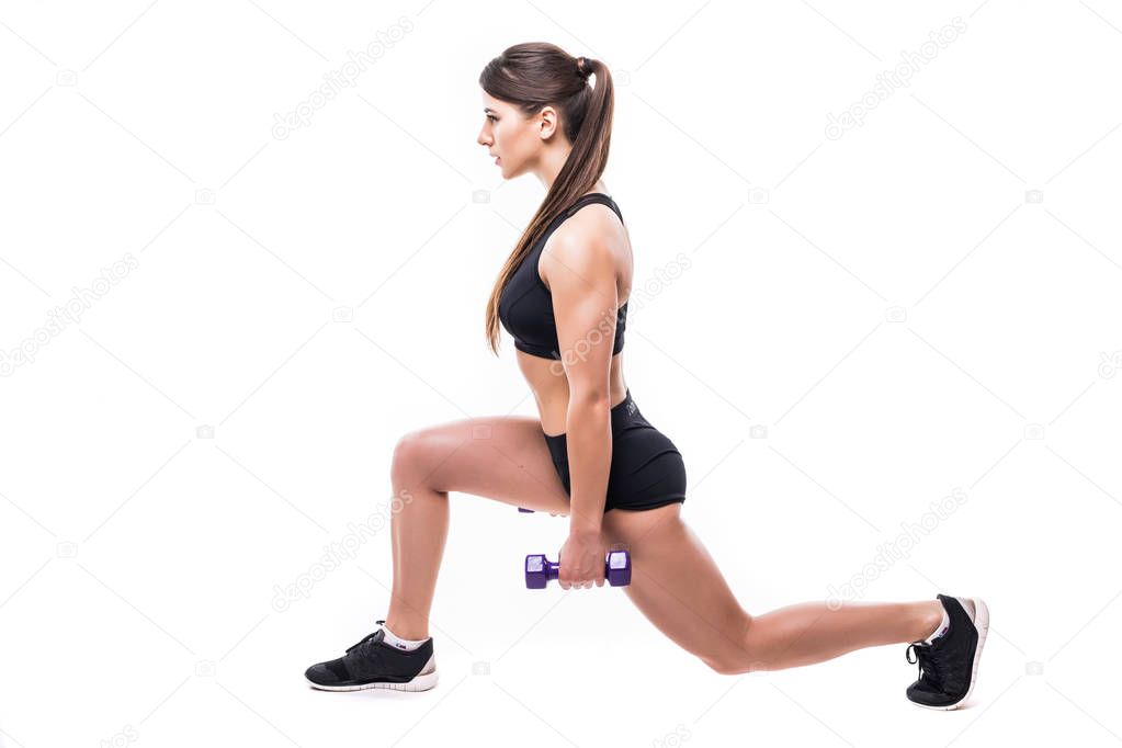 Beautiful young woman doing lunge exercise with red dumbbells in fitness gym isolated over white background