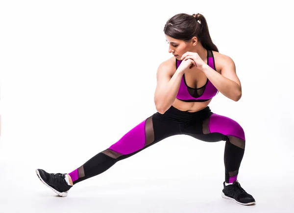 Hermosa joven hispana haciendo ejercicio de embestida en gimnasio sobre fondo blanco — Foto de Stock