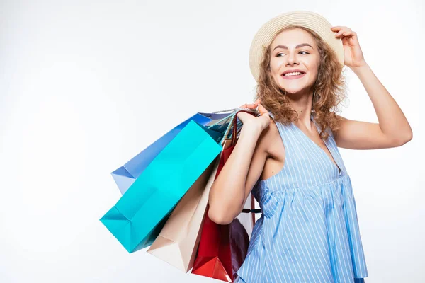 可爱的卷发妇女在夏天帽子与购物袋在白色背景 — 图库照片