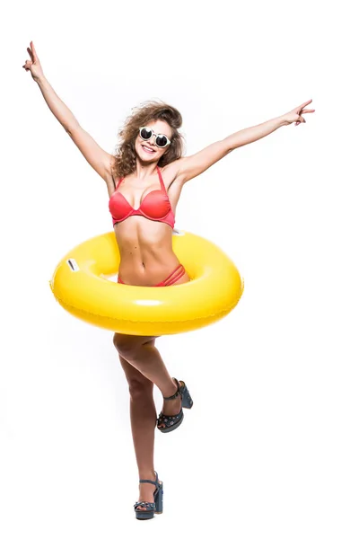 Volledige lengte portret van een gelukkig meisje gekleed in badpak in zonnebril reised handen met opblaasbare ring terwijl op witte achtergrond — Stockfoto