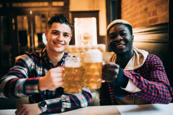 Primer plano de dos amigos felices bebiendo cerveza en un bar o pub — Foto de Stock