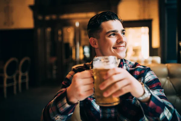 Ung man med dricka öl i en bar — Stockfoto