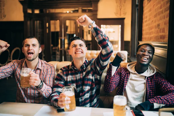 Sport, människor, fritid, vänskap och underhållning koncept - glad fotboll fläktar eller manliga vänner dricka öl och fira segern på bar eller pub — Stockfoto