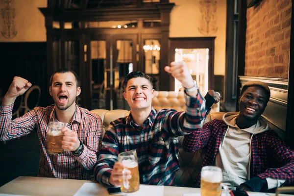 スポーツ、人々、レジャー、友情とエンターテイメントのコンセプト - 幸せなフットボールのファンや男性の友人がビールを飲むとで勝利を祝ってバーやパブ — ストック写真