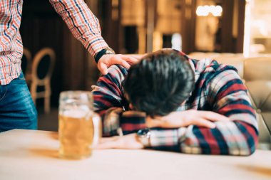 Genç adam sarhoş arkadaşı masada uyku uyanık bar veya pub