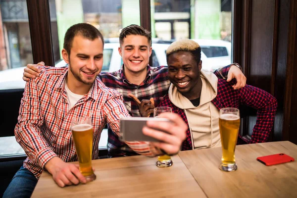 Glada gamla vänner har roligt tar selfie och dricka fatöl på pub. Öl pub — Stockfoto