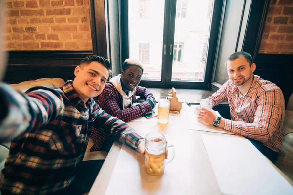 Velhos amigos alegres se divertindo tirando selfie e bebendo cerveja no bar — Fotografia de Stock