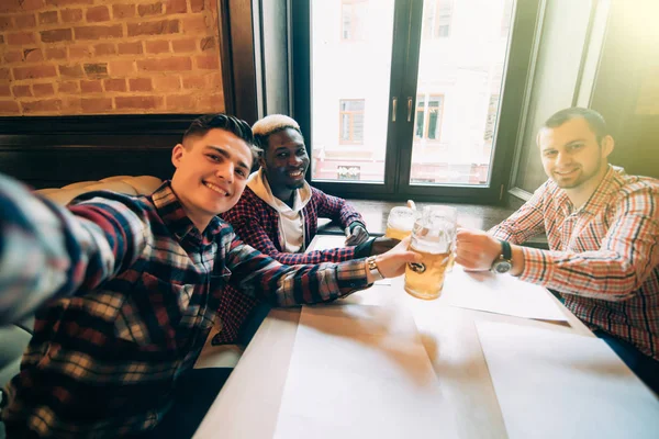 Glad mäns vänner tar selfie och druckit öl på puben — Stockfoto