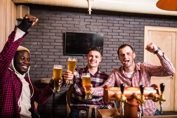 Grupo de amigos do sexo masculino assistindo jogo de futebol no pub ganhar grito — Fotografia de Stock