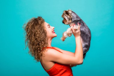 Güzel kadının Yorkshire terrier köpek ile kırmızı dresss içinde renk arka plan üzerinde izole öpücük verir