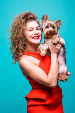 Güzel genç kadın ile sevimli yorkshire terrier köpek, yeşil arka plan üzerinde izole Kırmızı elbiseli