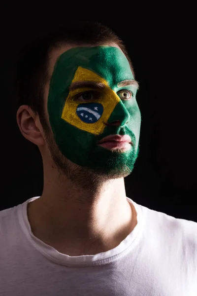 幸せなファンの顔の肖像画が暗い背景に分離の塗られた表面とブラジルの全国代表チームをサポートします。 — ストック写真