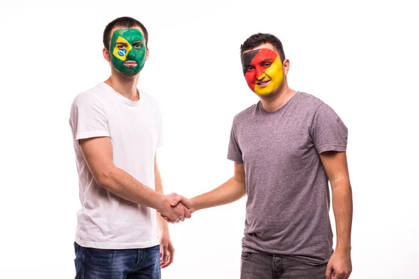 Fãs de futebol da Alemanha e do Brasil equipes nacionais com rosto pintado apertar as mãos sobre fundo branco — Fotografia de Stock