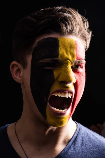 脸上的快乐球迷支持比利时国家队用画的脸在黑暗背景下呼喊 — 图库照片